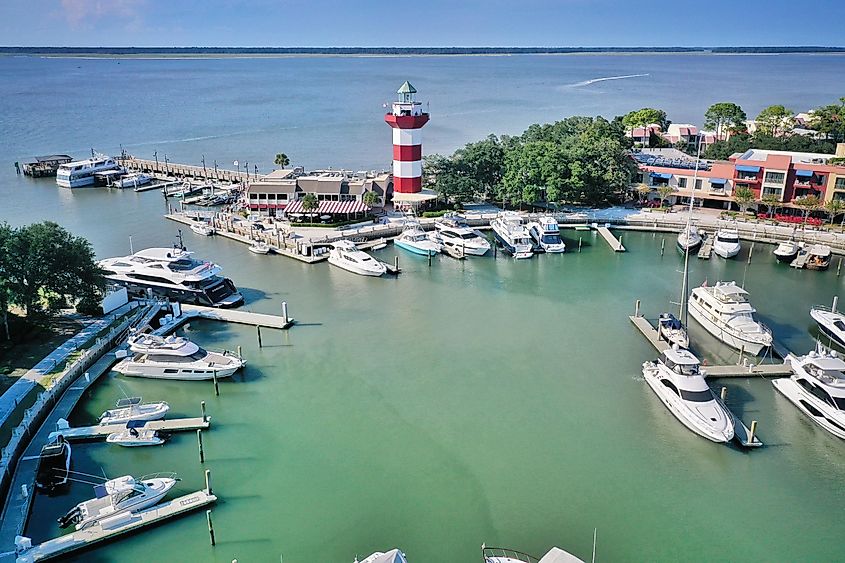 Aerial view of boats moored in the marina and a lighthouse on the pier