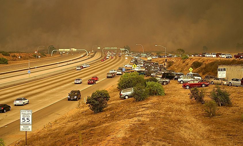 Cars scramble to exit the freeway by driving up the embankment to the on ramp, and moving against the flow of traffic in an effort to flee the flames as the Cedar fire crosses the I-15 freeway onto Marine Corps Air Station (MCAS) Miramar.