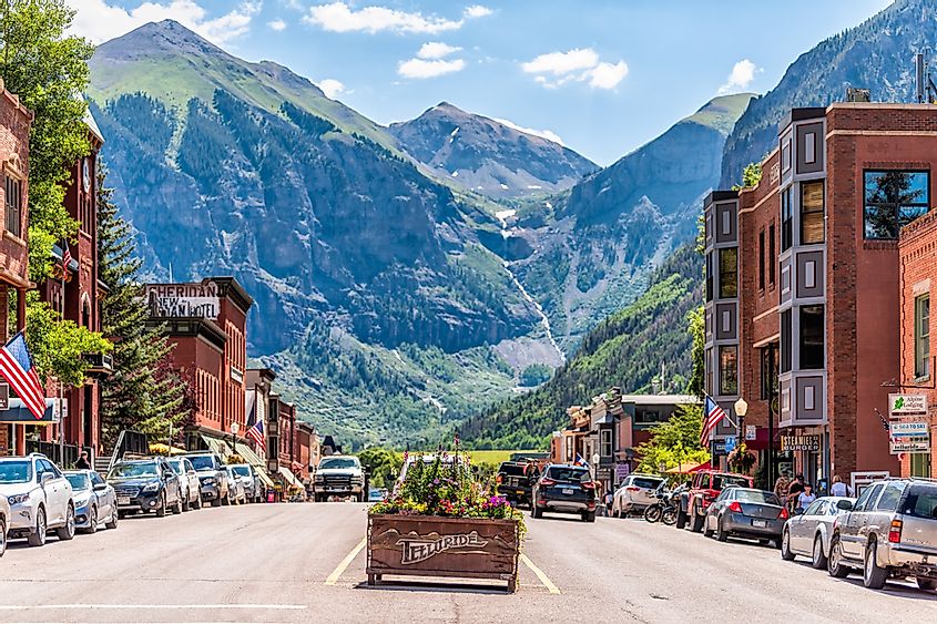 Telluride, USA - August 14, 2019: Small town village in Colorado with sign for city and flowers by historic architecture on main street mountain view