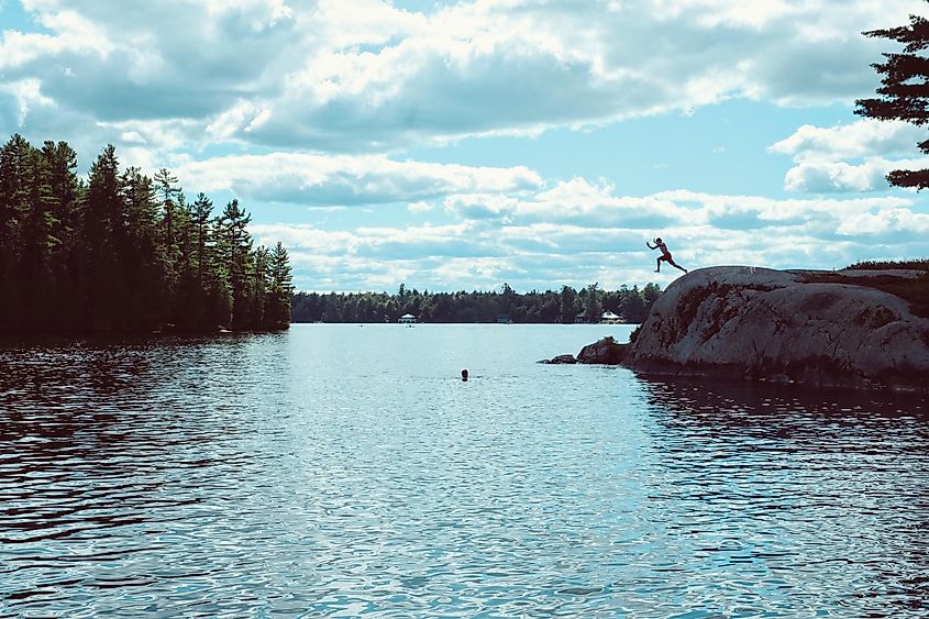 Children jump to water in Tupper Lake, Dark Silhouettes.