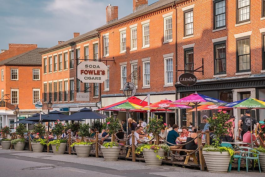 Retro sign in downtown Newburyport, MA, USA, with quaint streets lined with 19th-century brick buildings, trendy shops, and restaurants offering outdoor dining.