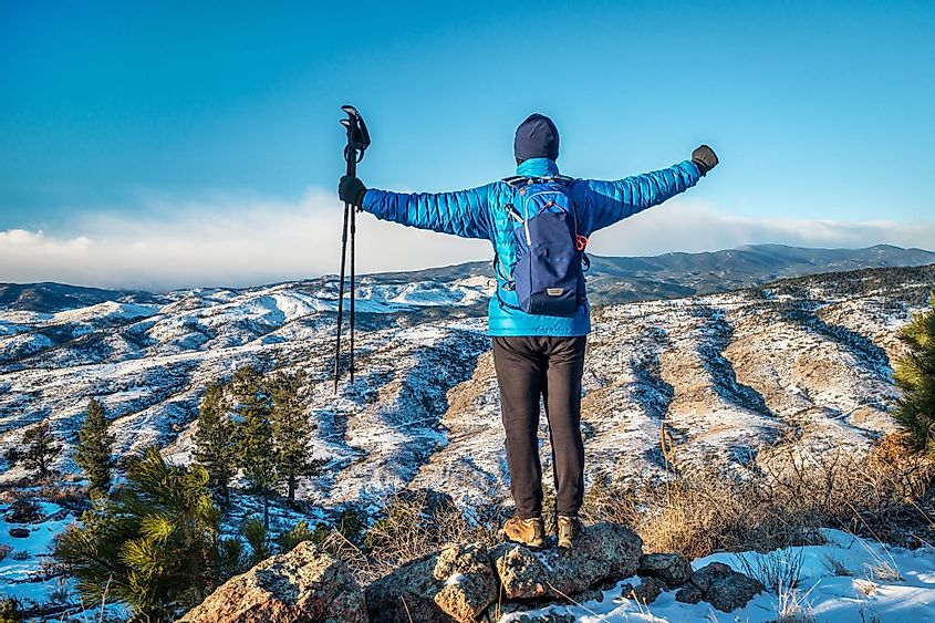A male hiker enjoying a view of the Rocky Mountain foothills during winter at Horsetooth Mountain Open Space near Fort Collins, Colorado