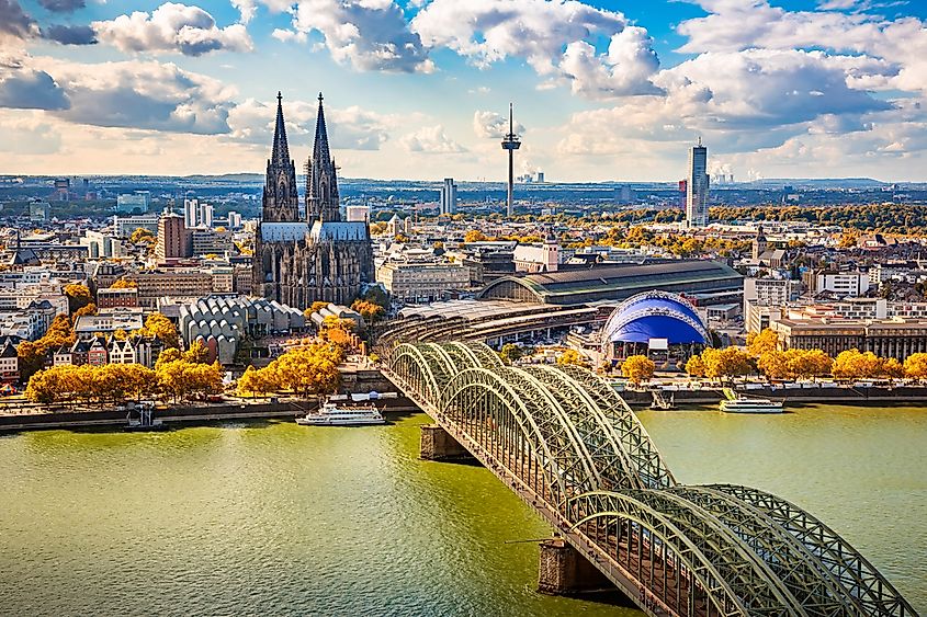 The Gothic spires of Cologne Cathedral and the city skyline along the Rhine River.
