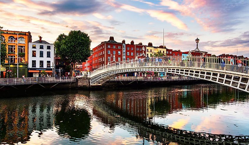 Night view of famous illuminated Ha Penny Bridge in Dublin, Ireland at sunset