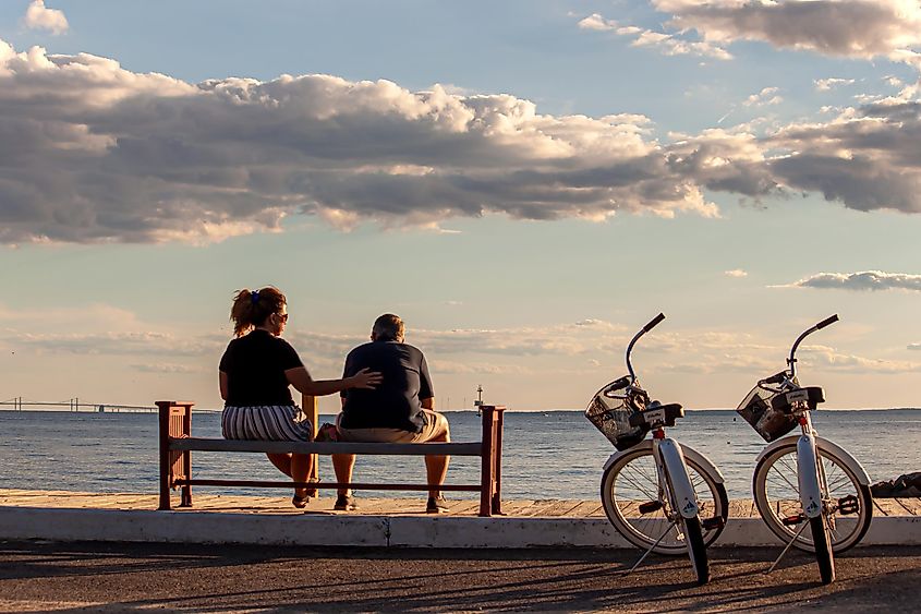 Rock Hall, Maryland: Couple Relaxing on Beach Bench with Bikes Nearby.