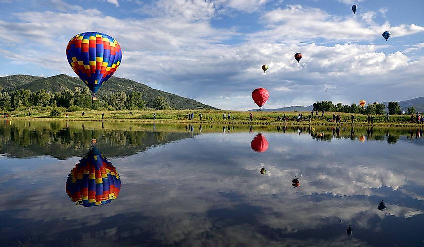 Balloons float over Bald Eagle Lake during the 38th annual Steamboat Springs Hot Air Balloon Festival in Steamboat Springs, Colorado 