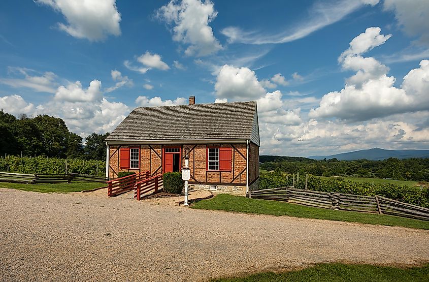 Luray, Virginia: The ancient Elk Run Dunkard Meeting House in the Shenandoah Heritage Village with the surrounding landscape.