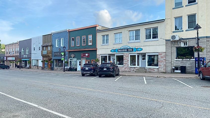 A string of colorful, small town, Old West style buildings beneath a blue sky.