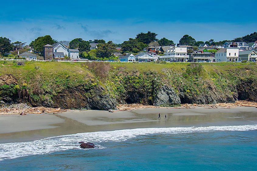 The seacoast village of Mendocino, California lines an ocean headland at low tide on a sunny spring afternoon