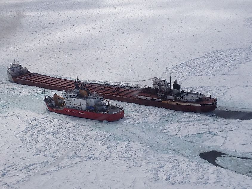 A Coast Guard icebreaker escorting a freighter through Lake Superior ice.
