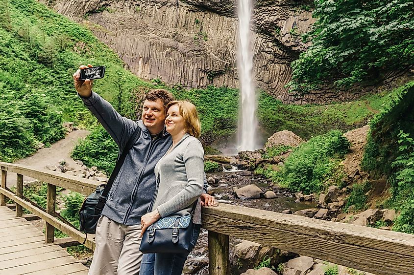 A couple taking selfie in front of Latourell Falls along the Columbia River Gorge, Oregon