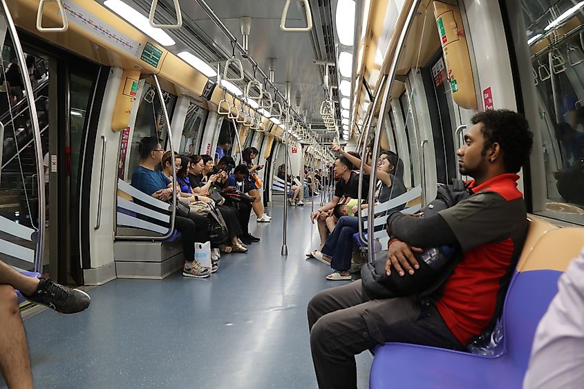 People ride public transport Singapore MRT train.