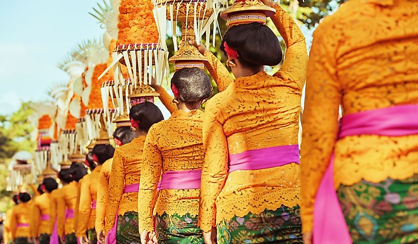 Procession of Balinese women in traditional costumes for Hindu ceremony on Bali island, Indonesia
