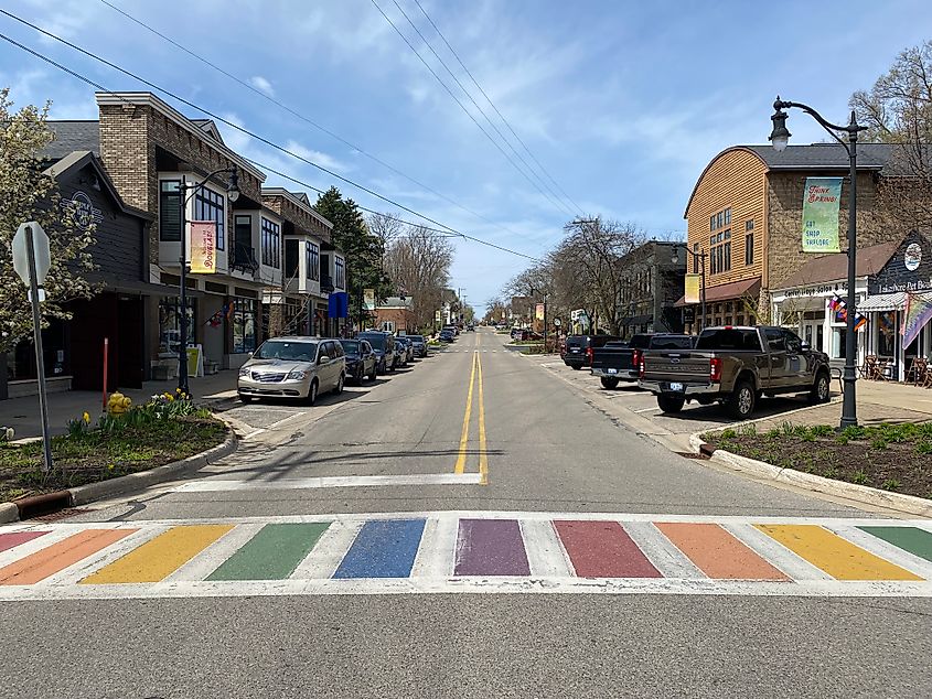 A rainbow crosswalk at the start of a small town's downtown district. 