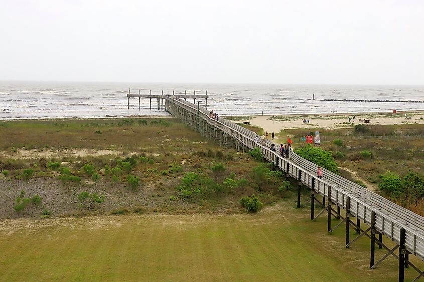 Way to the beach and pier along wooden boardwalk over the sand dunes at the Grand Isle State Park, Louisiana
