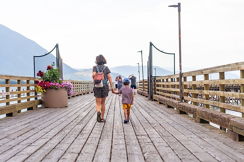 Mother and son enjoying a leisurely stroll along the wooden pier in Salmon Arm, BC.