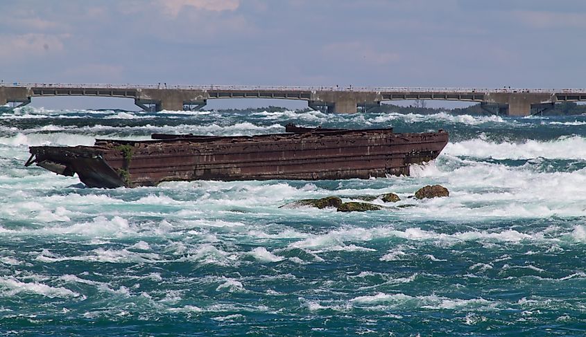 The rusting Niagara Scow above Niagara falls (iagara Falls acts as a massive, 170+ foot drop connecting the higher-elevation Lake Erie to the lower-elevation Lake Ontario via the Niagara River)