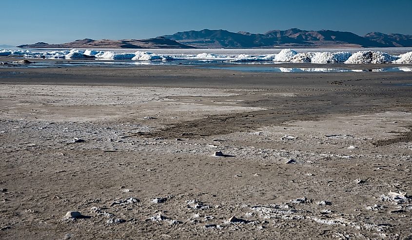 The vanishing Great Salt Lake with salt mounds in the near distance. Due to drought and poor irrigation practices this iconic lake is disappearing.