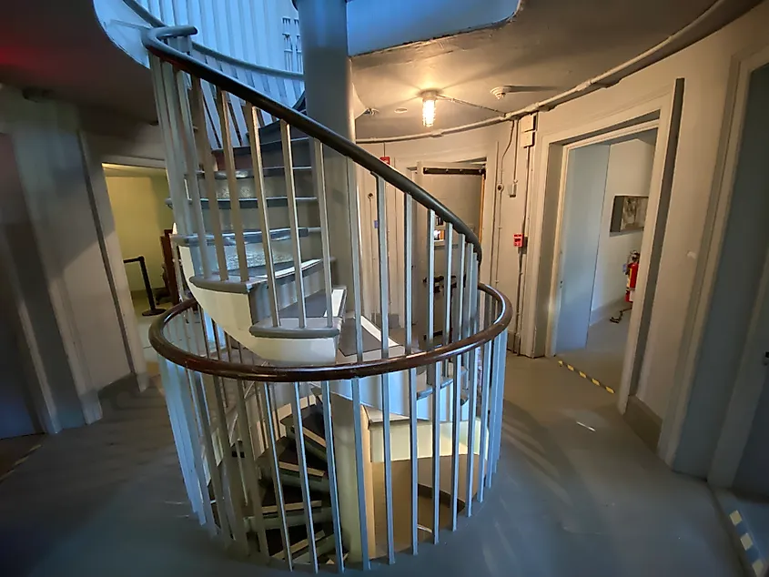A spiral staircase cuts through the center of an old jail. 