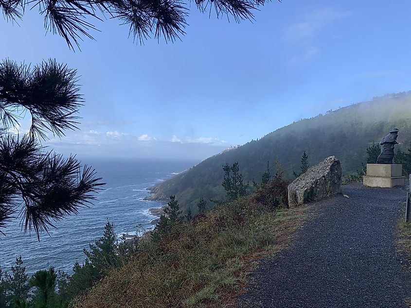 A beautiful coastline with a statue of a pilgrim standing on the shore. The vast North Atlantic Ocean just comes into view.