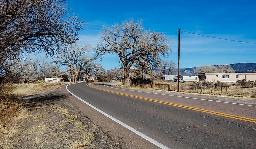 Bending roadway passing through small village in rural New Mexico on clear day