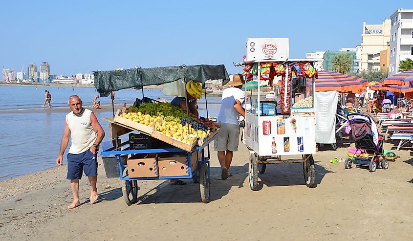Food and fruit merchants pass one after another all day long on the beach of Durres, Albania