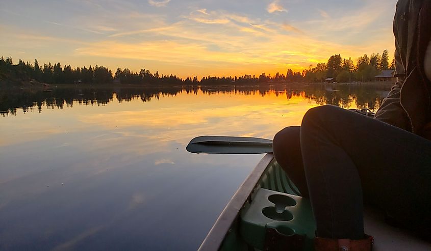 A woman canoeing at sunset at Badger Lake in Cheney, Washington.