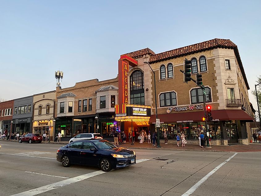 Dusk outside of the Arcada marquee theatre, whose patrons emerge onto a lively main street.