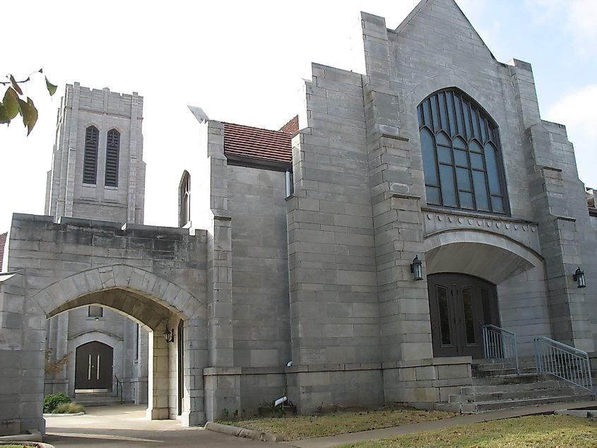 Exterior of the Presbyterian Church in Bristow, Oklahoma, with red brick walls, arched windows, and a central bell tower