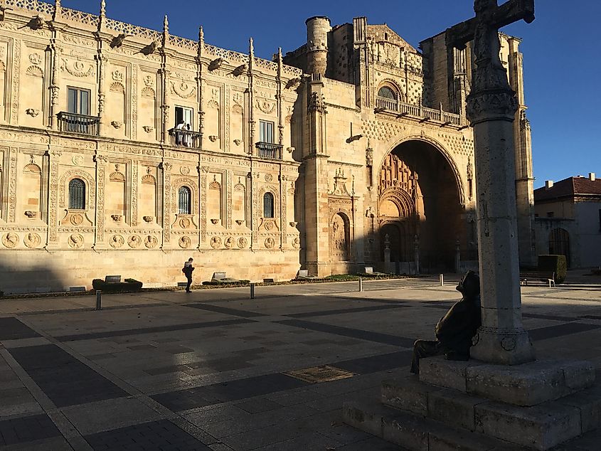 A statue of a pilgrim sits and looks pensively at the grand Hostal de Leon - an old pilgrim's hospital that now acts as a fancy hotel.  