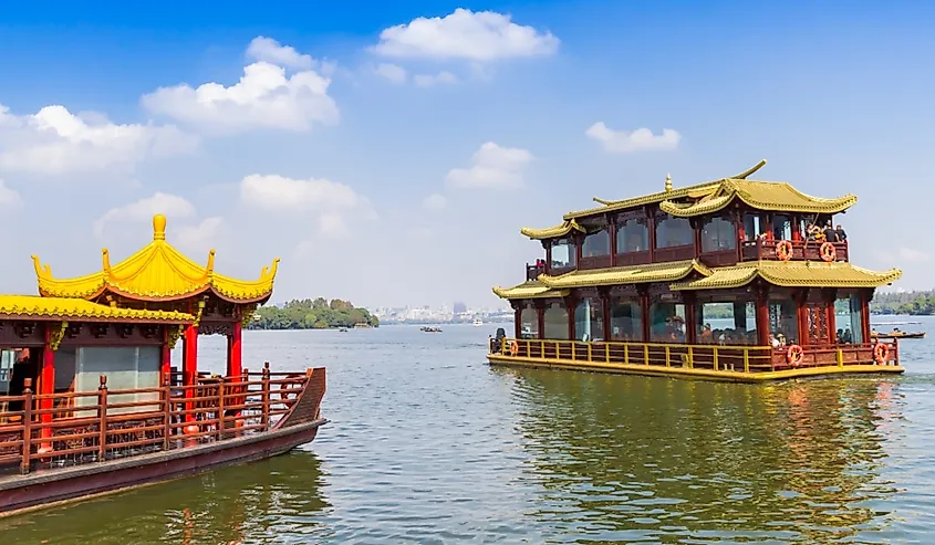 Tourist cruise boats in traditional chinese style on the West lake in Hangzhou, China.