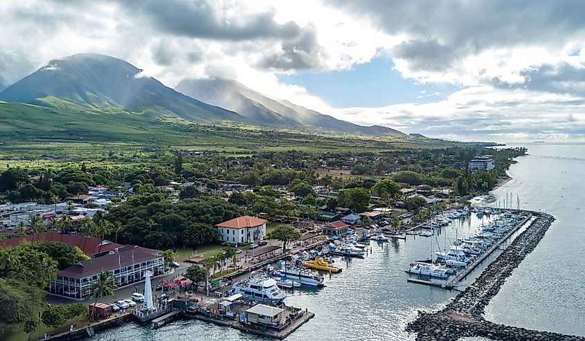 Drone images over Lahaina, Hawaii with lush mountains and a boat dock and pier in 2017
