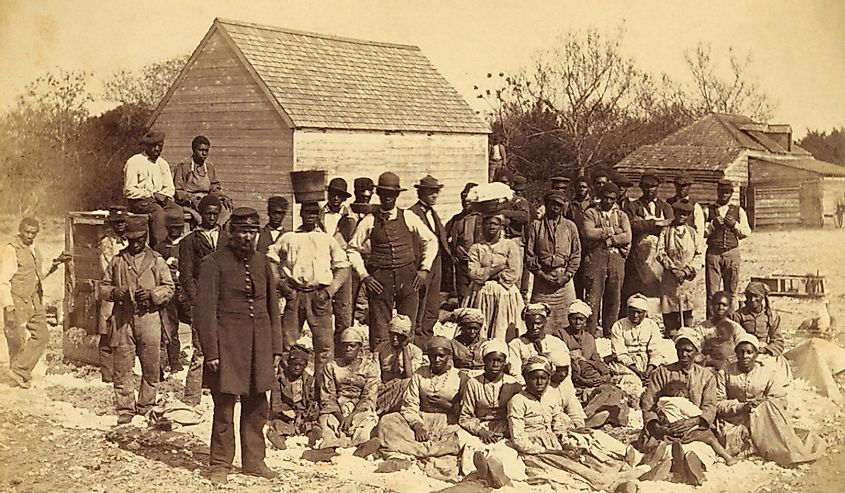A Union soldier standing next to a group of freed slaves in 1862.