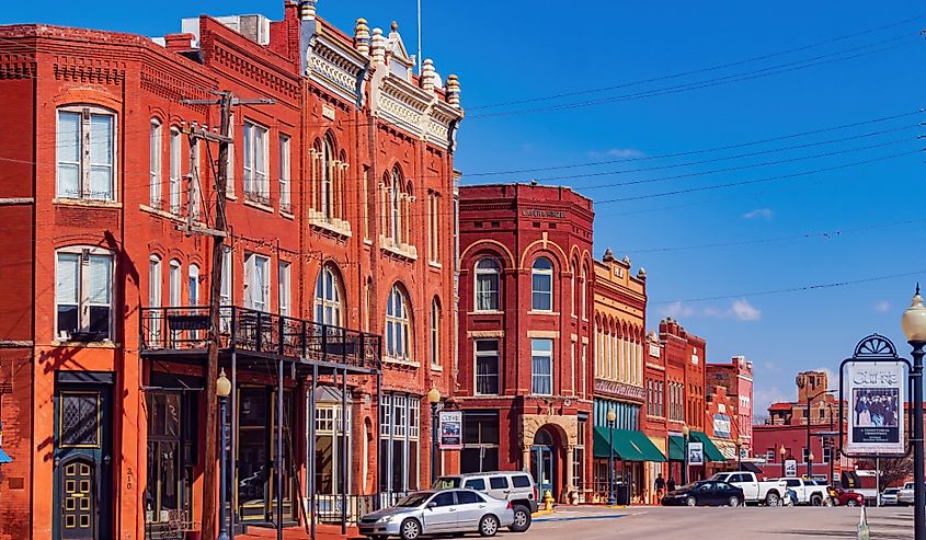 Sunny exterior view of the Guthrie old town with red buildings and street view