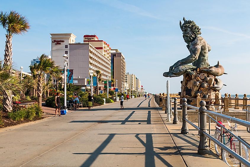 The King Neptune statue by sculptor Paul DiPasquale along the 3-mile long oceanfront boardwalk on Virginia Beach lined with high-rise hotels, via Sherry V Smith / Shutterstock.com