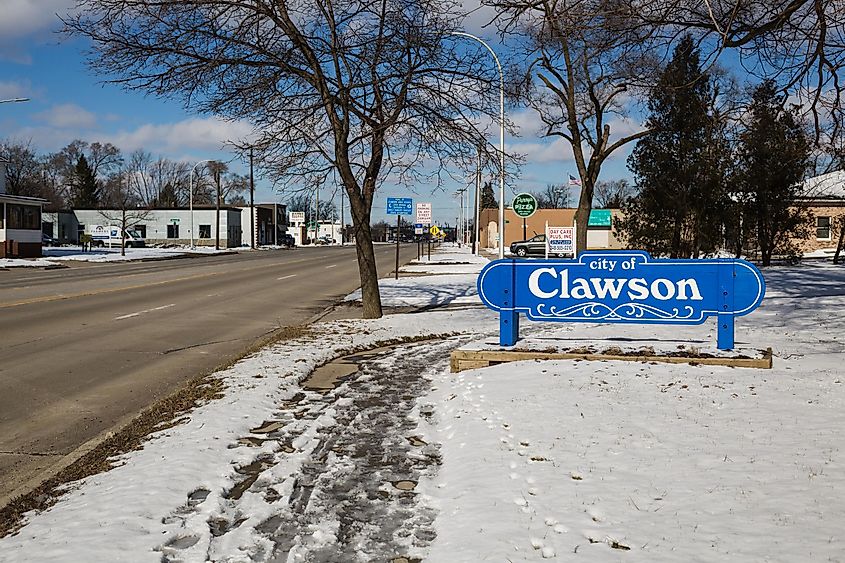 Clawson, Michigan sign with snow-covered ground, clear street and sign.