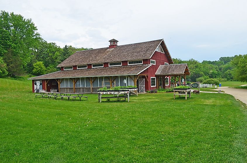 : a red barn on a green field / Lilian Goldman Visitor's Center at the Seed Savers Exchange Heritage Farm at Decorah, Iowa, via BePhumirat / Shutterstock.com