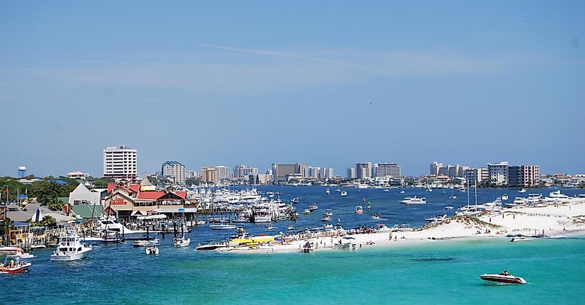 Panoramic view of Destin, Florida from the Destin Harbor, with boats and waterfront buildings lining the harbor.
