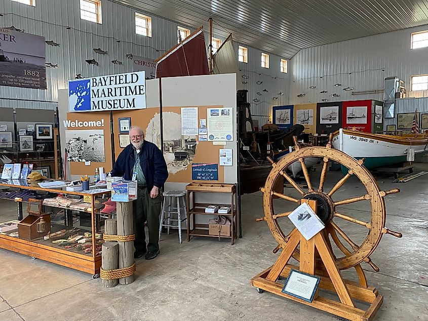 A smiling old man working the entrance of the artifact-rich Bayfield Maritime Museum.