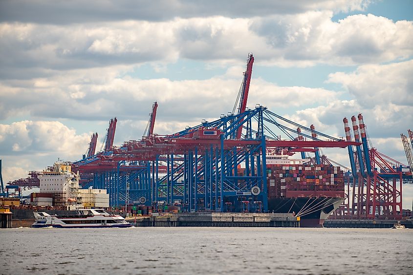 Container cargo ship in a commercial dock. New York container port. Ship container port. Container terminal in the port. Terminal port. Via Shutterstock / K-Shoot Background