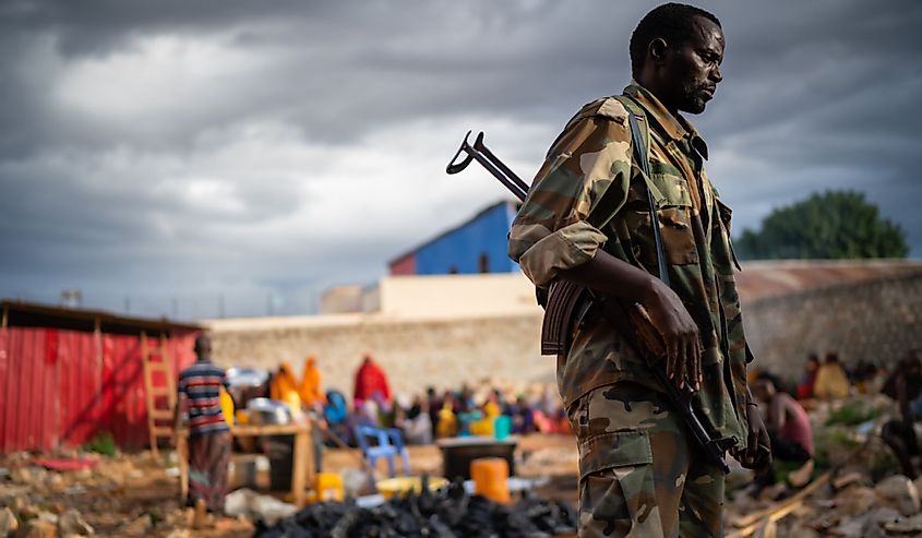 Yemek sırasında insanları korumak için görevli asker, Baidoa, Somali