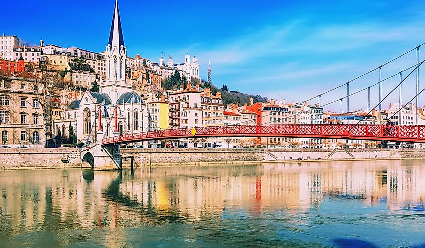 Pedestrian Saint Georges footbridge and the Saint Georges church in Lyon, France in a beautiful spring day