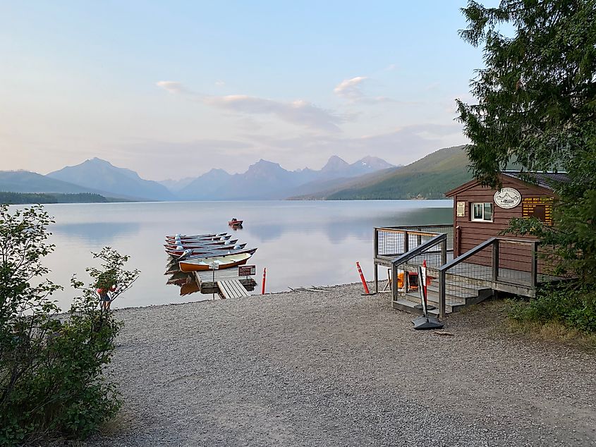 A pastel sky overhangs the Rocky Mountains and Lake McDonald as seen from an empty Apgar Beach.