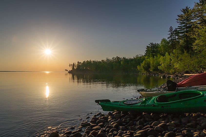 Sunrise at Town Beach, Madeline Island with kayaks on the rocky shore.