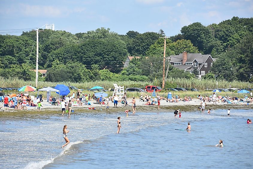People sunbathing, swimming, and playing on a beach in Jamestown, Rhode Island.