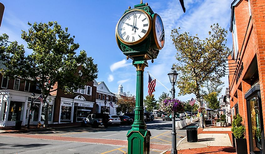 Downtown on a nice day with clock, store fronts, restaurant and blue sky on Elm Street in New Canaan