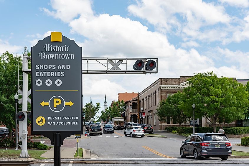  Historic Downtown sign near railroad tracks with downtown Opelika traffic in the background, Opelika, Alabama, USA.