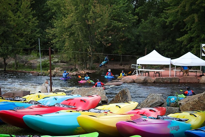 Colorful kayaks lined up at Wausau Whitewater Park in Wisconsin.