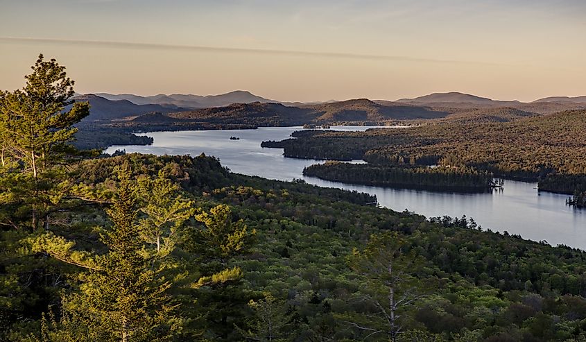 Atop Bald Mountain overlooking several lakes and mountain ranges at sunset in the Adirondack Mountains of upstate New York.