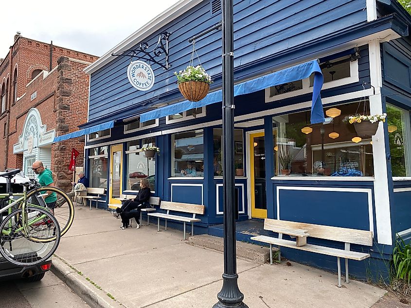 Street side out front of a blue panelled coffee shop.